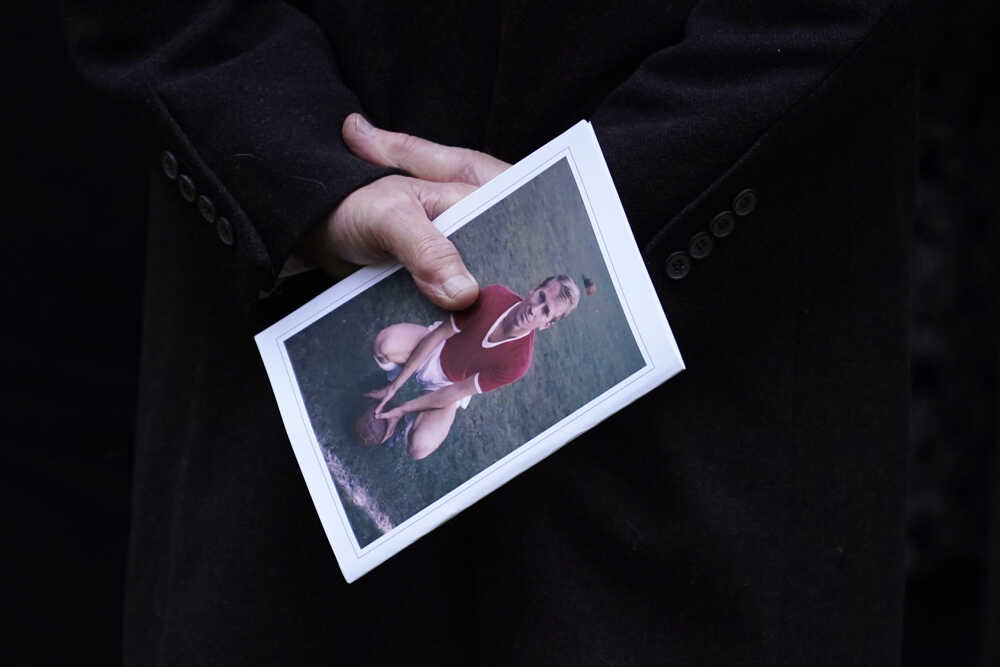 Muž drží program pohrebu futbalovej legendy Manchestru United Bobyho Charltona pred katedrálou v Manchestri.