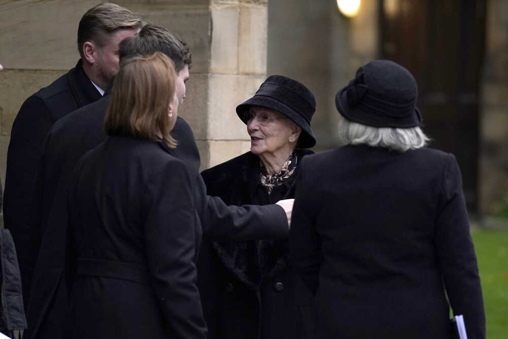 Norma Charltonová, manželka futbalovej legendy Manchestru United Bobyho Charltona, hovorí s príbuznými pred katedrálou.
