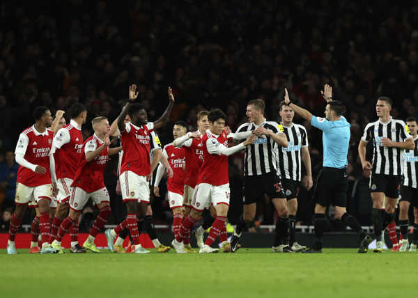 Druhý sprava rozhodca Andy Madley diskutuje s hráčmi Arsenalu.