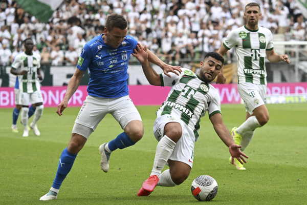 Futbalista KI Klaksvík Arni Frederiksberg (vľavo) a hráč Ferencvárosu Budapešť Mohammed Abu Fani bojujú o loptu.