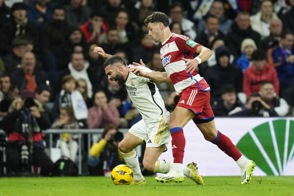 Hráč Realu Madrid Dani Carvajal (vľavo) a hráč Granady Lucas Boye bojujú o loptu.