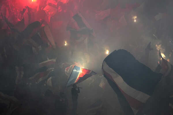 Futbaloví fanúšikovia Paríža St. Germain zapaľujú svetlice počas zápasu s Milánom.