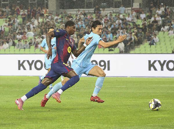 Hráč FC Barcelony Marcus Rashford (vľavo) a Woo Hoo-sung z Daegu počas priateľského zápasu.