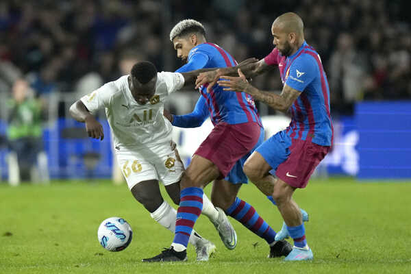 Nestory Irankunda (vľavo) z tímu A-Leagues All Stars a dvojica hráčov FC Barcelony Dani Alves (vpravo) a Ronald Araujo.