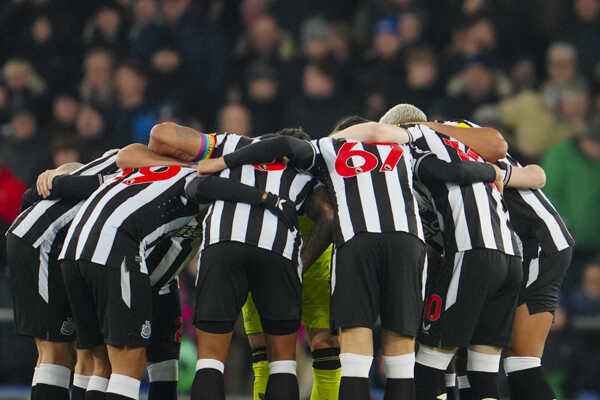 Futbalisti Newcastle United stoja v kruhu pred zápasom.