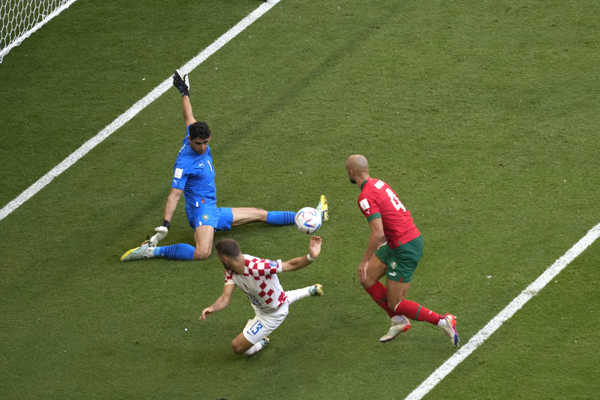 Marocký brankár Yassine Bounou chytá loptu pred Chorvátom Nikolom Vlašičom. Marocký brankár Yassine Bounou chytá loptu pred Chorvátom Nikolom Vlašičom.