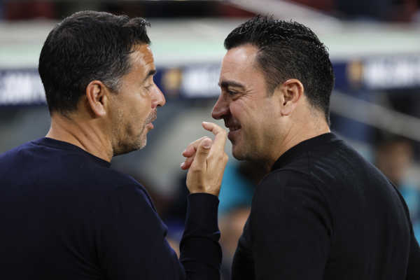 Sprava tréner Barcelony Xavi Hernandez a tréner Girony Michel sa rozprávajú pred zápasom.